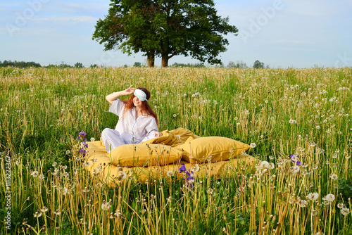 A woman woke up in a sunny meadow with wild flowers photo