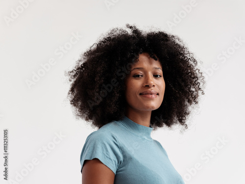 Confident Woman Smiling in Blue Sweater Against Plain Background photo