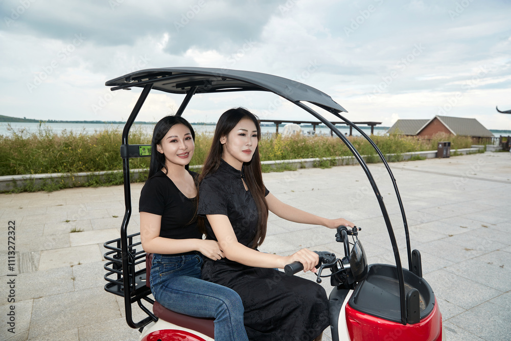 Two girls driving a sightseeing car to visit the scenic spot Two girls driving a sightseeing car to visit the scenic spot