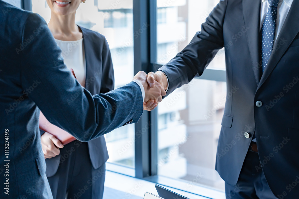 © ponta1414 - オフィスで握手をするビジネスパーソン