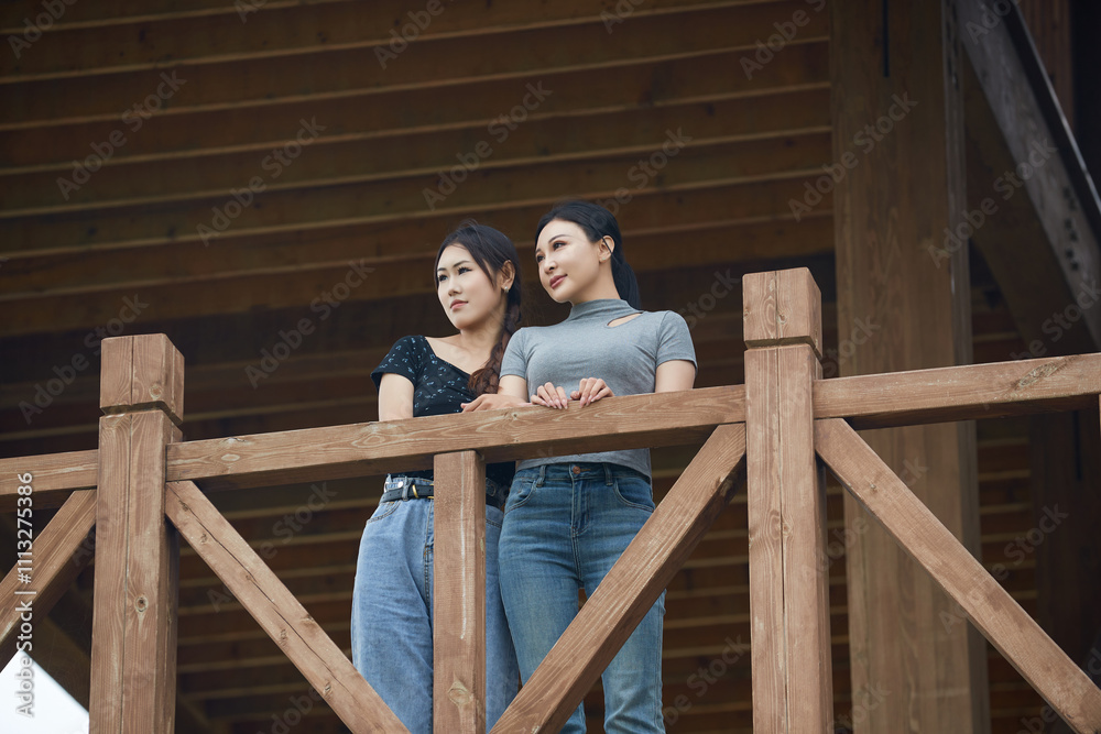 Beautiful girlfriends taking photos and playing at the bird watching platform in the grassland flower sea Beautiful girlfriends taking photos and playing at the bird watching platform in the grassland flower sea