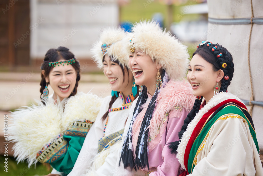 Girls wearing Tibetan costumes taking photos on the grassland Girls wearing Tibetan costumes taking photos on the grassland