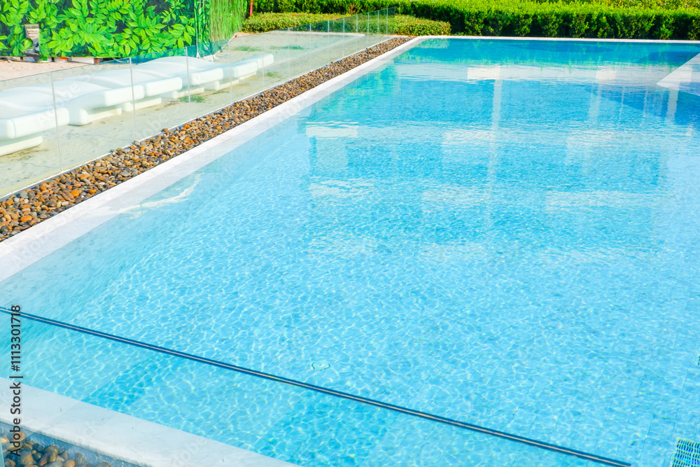 Obraz premium Empty swimming pool with sunbed and white umbrella in resort hotel for vacation leisure and white sand,resort neary sea and beach in summer..