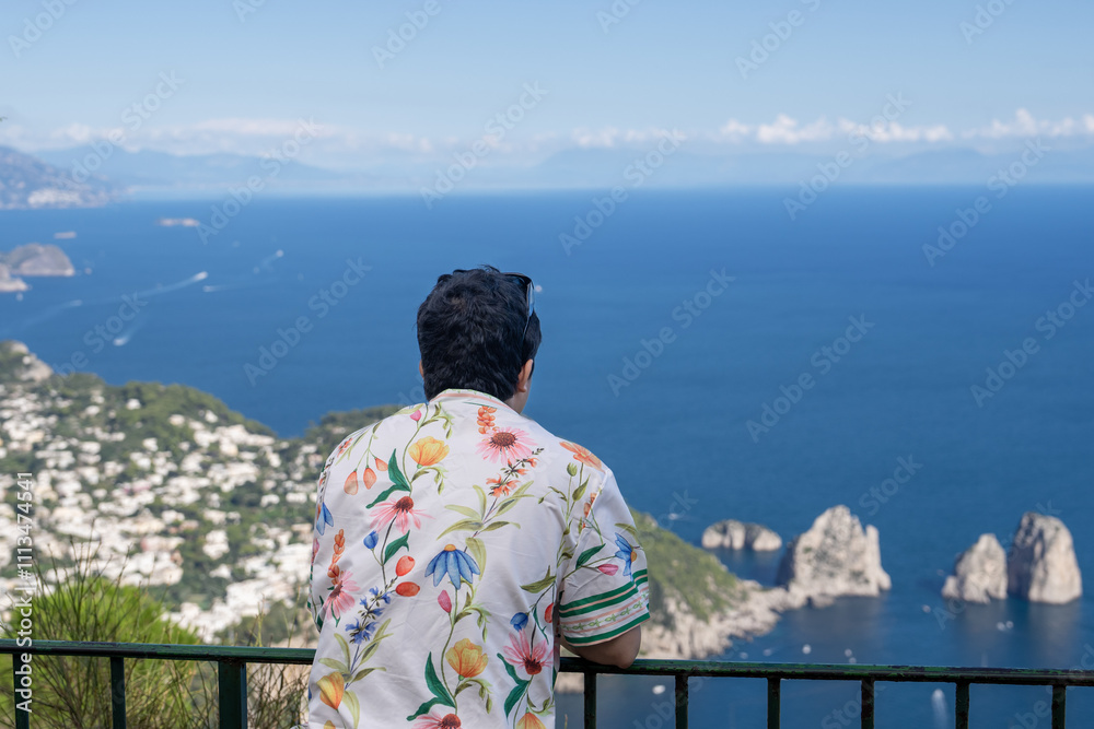 Man enjoy view of beautiful coastal cliffs faraglioni di mezzo from Monte Solaro in Capri, Italy. Man enjoy view of beautiful coastal cliffs faraglioni di mezzo from Monte Solaro in Capri, Italy.