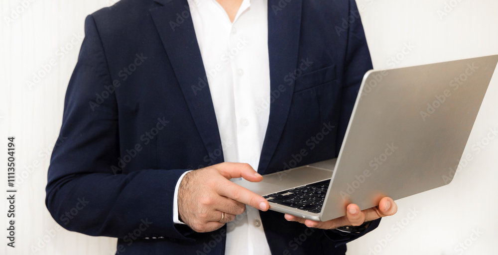 Man in a suit with glasses, throwing a crumpled paper into a small office trash bin.worker on clean background having surprised face expression.guy with laptop smiling against wall. Man in a suit with glasses, throwing a crumpled paper into a small office trash bin.worker on clean background having surprised face expression.guy with laptop smiling against wall.