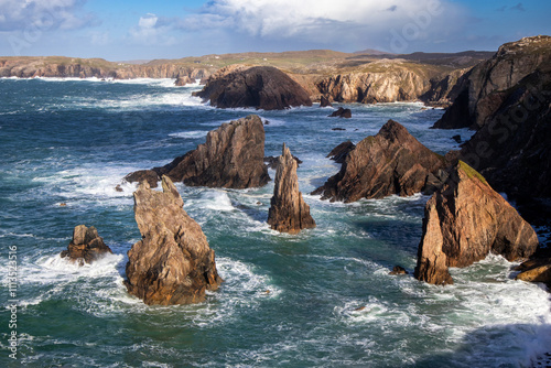 Mangersta sea stacks with rough sea and breaking waves and surf around bases photo