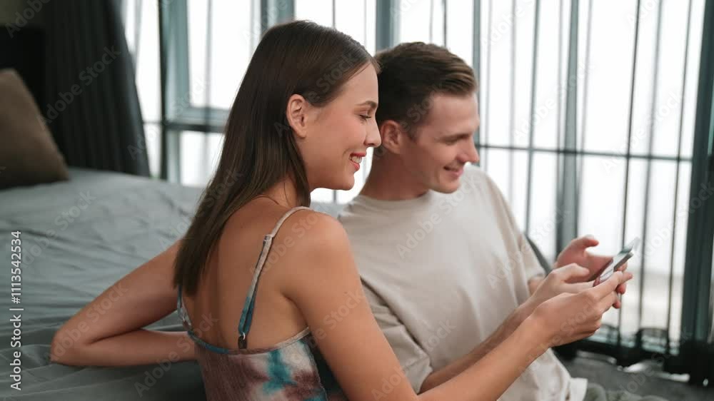 Young couple sit in the home bedroom using online payment app and digital wallet on smartphone to pay with credit card. E commerce shopping and modern purchasing via mobile internet. Adit Young couple sit in the home bedroom using online payment app and digital wallet on smartphone to pay with credit card. E commerce shopping and modern purchasing via mobile internet. Adit