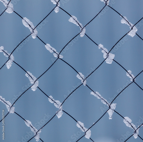 A blue and white fence with snow on it photo