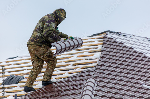 A man in camouflage is working on a roof