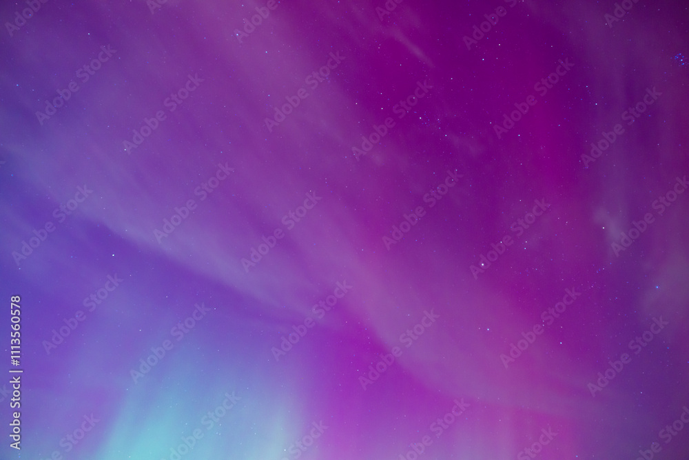 Fototapeta premium Vivid pink and magenta aurora borealis glowing in starry sky