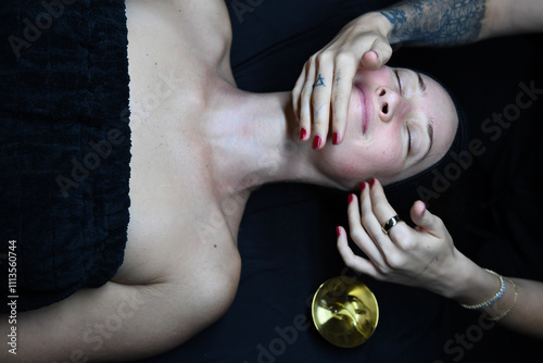 Gentle facial massage using golden oil for relaxation and rejuve photo