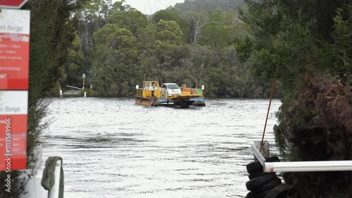 Famous barge crossing Pieman River at Corinna. Carrying cars. Ferry. . Slow motion footage. Pieman River Cruise. Corinna, Tasmania, Australia. photo