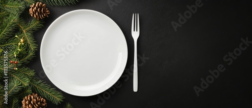 Empty plate on black table with pine branches and pine cones arranged artisti...