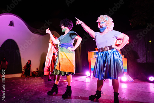Obraz na płótnie Drag queens performing on stage with rainbow flag at night