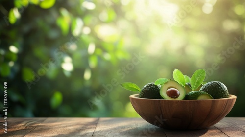 Fresh avocados in a wooden bowl on a table in a sunny outdoor setting surroun...