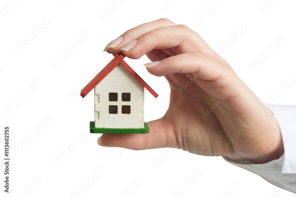 A female hand in a white shirt holding a small house A female hand in a white shirt holding a small house