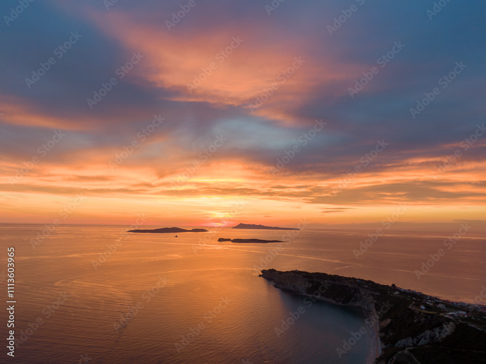 aerial view of a Arillas beach at sunset. Golden hues paint the sky and water, with a pier stretching into the calm sea. Corfu,Greece,Europe aerial view of a Arillas beach at sunset. Golden hues paint the sky and water, with a pier stretching into the calm sea. Corfu,Greece,Europe
