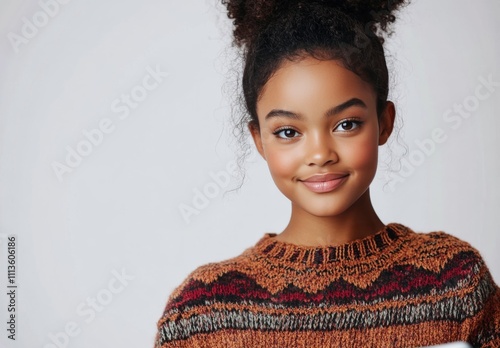 Young woman in cozy sweater smiles while working on laptop at home