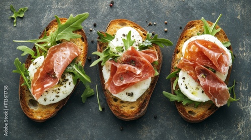 Delicious sandwich with fresh mozzarella, prosciutto, and arugula on rustic b...