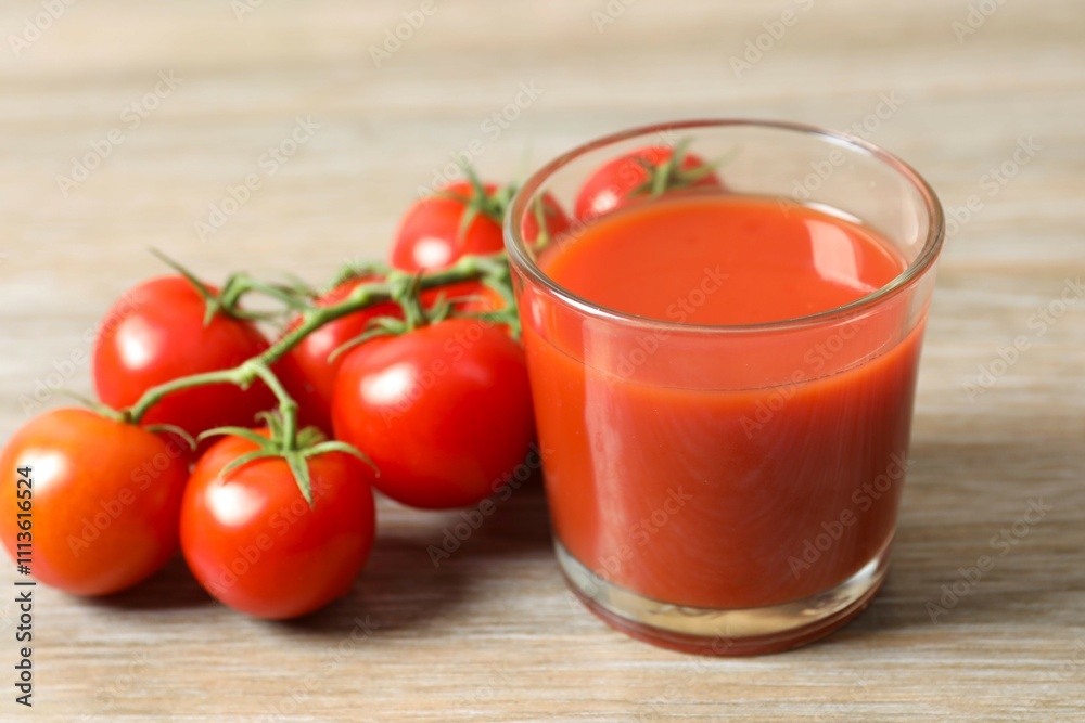Tomato juice in a glass and fresh tomatoes on the table Tomato juice in a glass and fresh tomatoes on the table