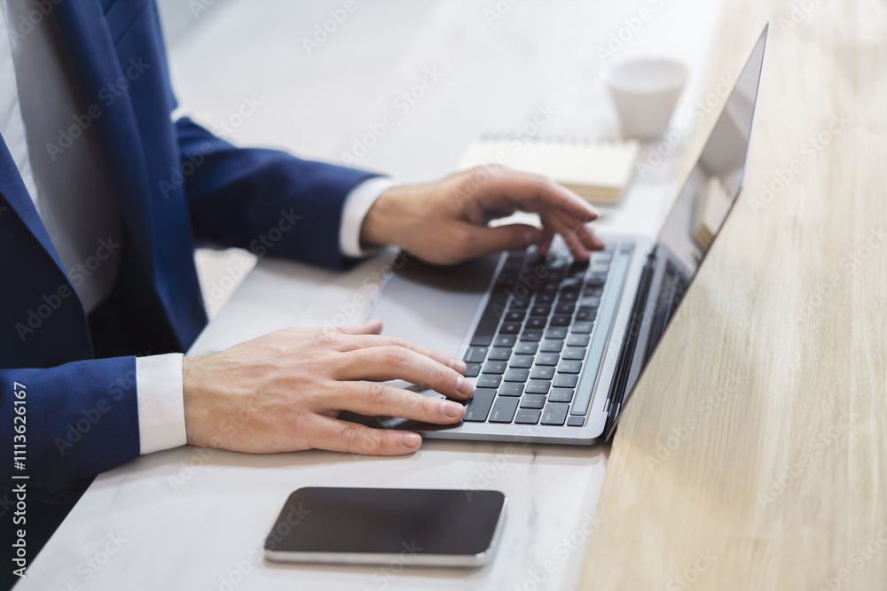 Against a softly blurred office scene, a man's hands are shown in detail, typing on a state-of-the-art laptop keyboard Against a softly blurred office scene, a man's hands are shown in detail, typing on a state-of-the-art laptop keyboard