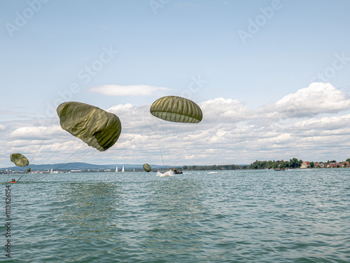 German paratroopers participate in a NATO exercise, descending with precision from aircraft using parachutes. Demonstrating skill and teamwork, they train for rapid deployment in joint military operat