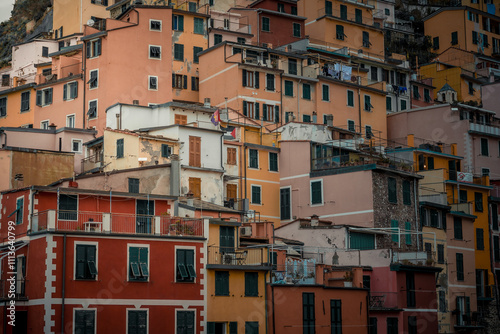 A captivating view of Manarola, one of the iconic villages of Cinque Terre, Italy. Vibrant houses are perched on a dramatic cliff overlooking the turquoise waters of the Ligurian Sea. 