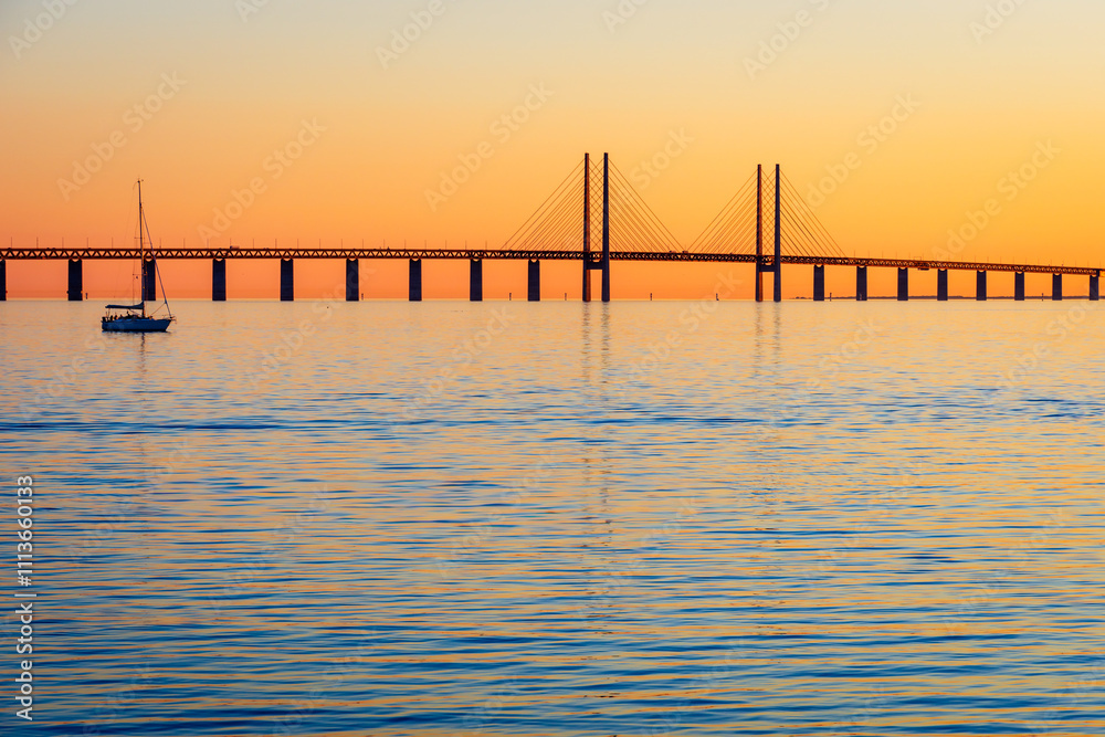 Sunset view of the Oresund bridge from the swedish shore, a railway and motorway cable-stayed bridge across the Oresund strait between Denmark and Sweden, opened to traffic in 2000. Sunset view of the Oresund bridge from the swedish shore, a railway and motorway cable-stayed bridge across the Oresund strait between Denmark and Sweden, opened to traffic in 2000.