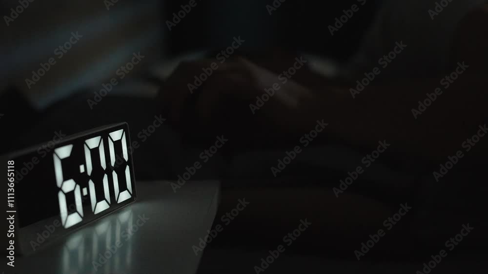 Man waking up at 6 a.m with digital alarm clock
