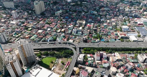Drone view of vehicles running on skyway. Hotels and residential area in Makati, Metro Manila. Philippines.