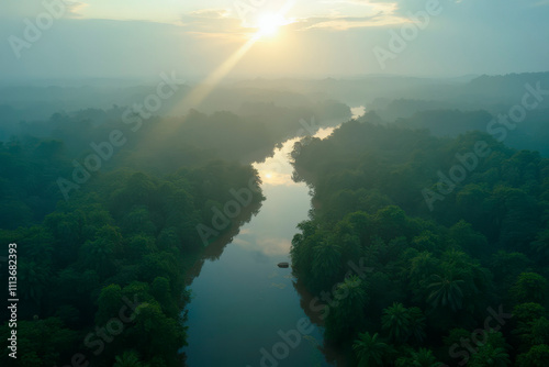 River in lush green rainforest at sunrise with fog