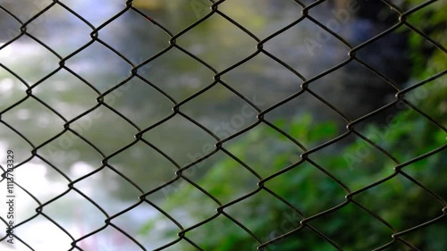 View of the river flowing behind a wire fence