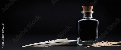 A vintage bottle of ink and quill feathers on a black background for artistic writing photo