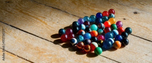 A vibrant collection of colorful marbles on sunbleached wooden background photo