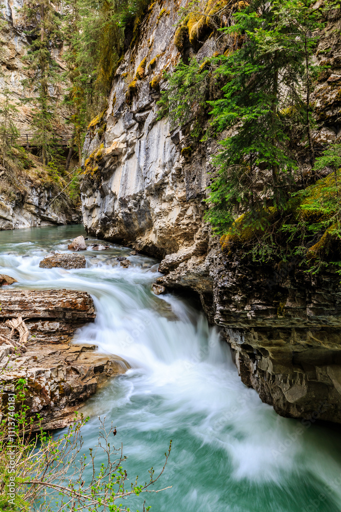 A waterfall is flowing down a rocky cliff A waterfall is flowing down a rocky cliff