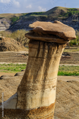 A large rock formation with a small cap on top photo