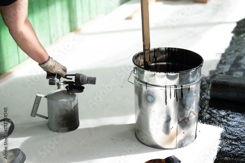 The method of heating resin in a bucket using a kerosene lamp at home. photo