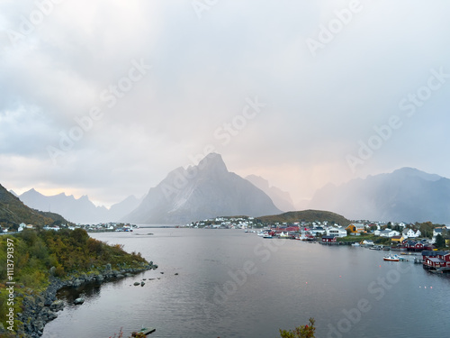 Autumn sunset in Reine, Lofoten Islands, Norway, with dramatic mountains, calm waters, and traditional houses along the shore. photo