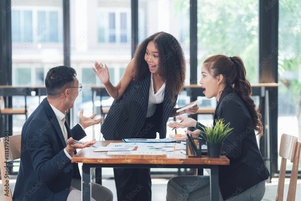 Business Meeting Excitement: Three diverse professionals, a man and two women, engage in an animated discussion around a table in a modern office setting. Business Meeting Excitement: Three diverse professionals, a man and two women, engage in an animated discussion around a table in a modern office setting.