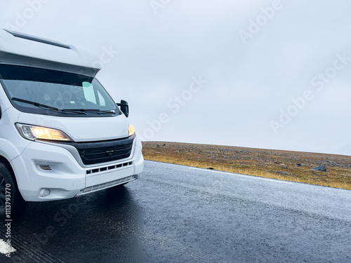 Camper van traveling on the e69 road to nordkapp, norway, on a rainy and foggy day photo