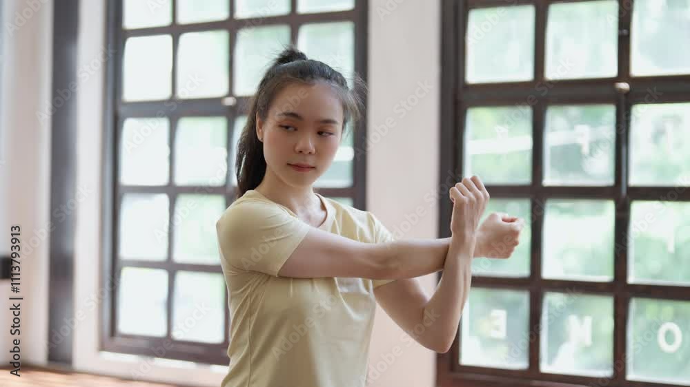 athlete asian woman doing warming up exercise at home
