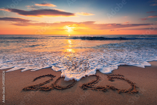 Fototapeta Naklejka Na Ścianę i Meble -  Happy New Year 2025 text lettering on the beach sand beautiful sunrise over sea horizon