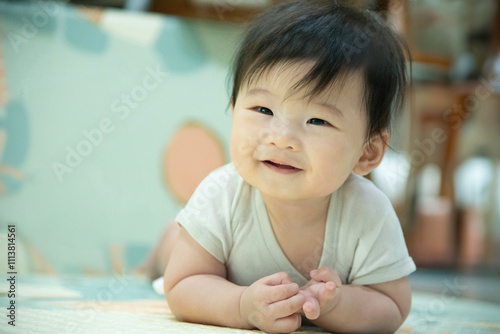 Adorable Baby laying on stomach developing neck control .tummy time for strengthen baby neck and shoulder muscles. Cute infant lying crawling on white bed happiness and fun. Tummy Time Concep