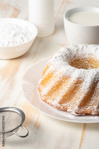 Homemade vanilla bundt cake on white wooden background. photo