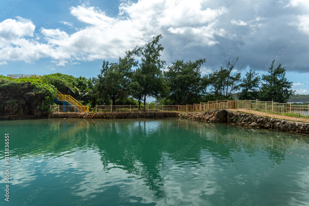 Fototapeta premium Snorkeling adventures await in the tranquil waters of Inalåhan, Guam, surrounded by lush nature