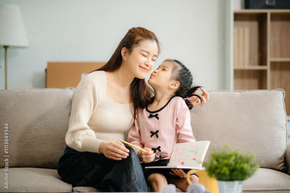 A caring mother and young daughter share a bonding moment doing homework at home.