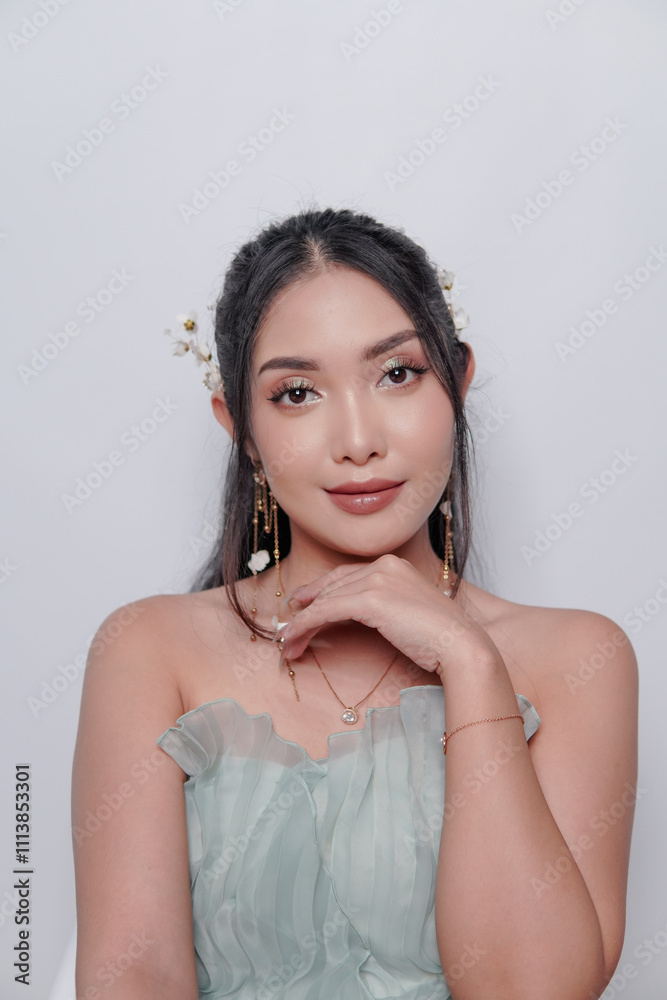 Smiling young Asian woman wearing luxurious dress and full make up.