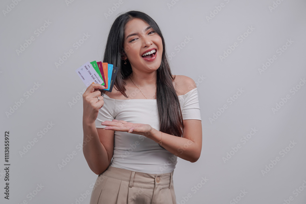 Excited young Asian woman presenting credit cards or debit cards, isolated by white background. Excited young Asian woman presenting credit cards or debit cards, isolated by white background.