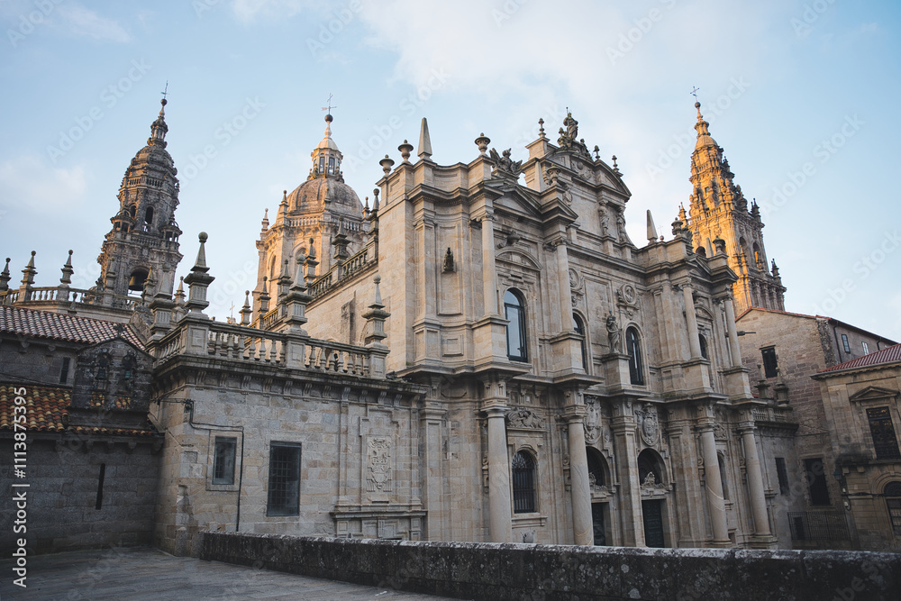 The baroque facade of the cathedral of santiago de compostela, bathed in the golden light of the setting sun The baroque facade of the cathedral of santiago de compostela, bathed in the golden light of the setting sun