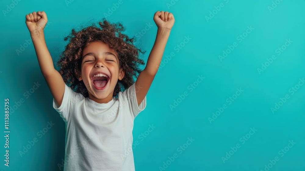 An enthusiastic child, with curly hair and a wide smile, stands against a blue wall with arms raised in celebration, exuding energy, joy, and a triumphant spirit. An enthusiastic child, with curly hair and a wide smile, stands against a blue wall with arms raised in celebration, exuding energy, joy, and a triumphant spirit.